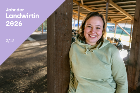 Laura Stolley steht angelehnt in einem ihrer Kuh-Ställe. Das Licht scheint von draußen in die Freilandboxen