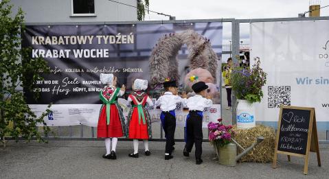 Kinder in sorbische Tracht öffnen das Hoftor